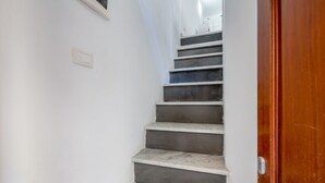 A staircase with alternating dark and light steps leading to a landing.