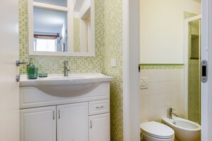 Ein Badezimmer mit Waschbecken, Spiegel und Toilette.