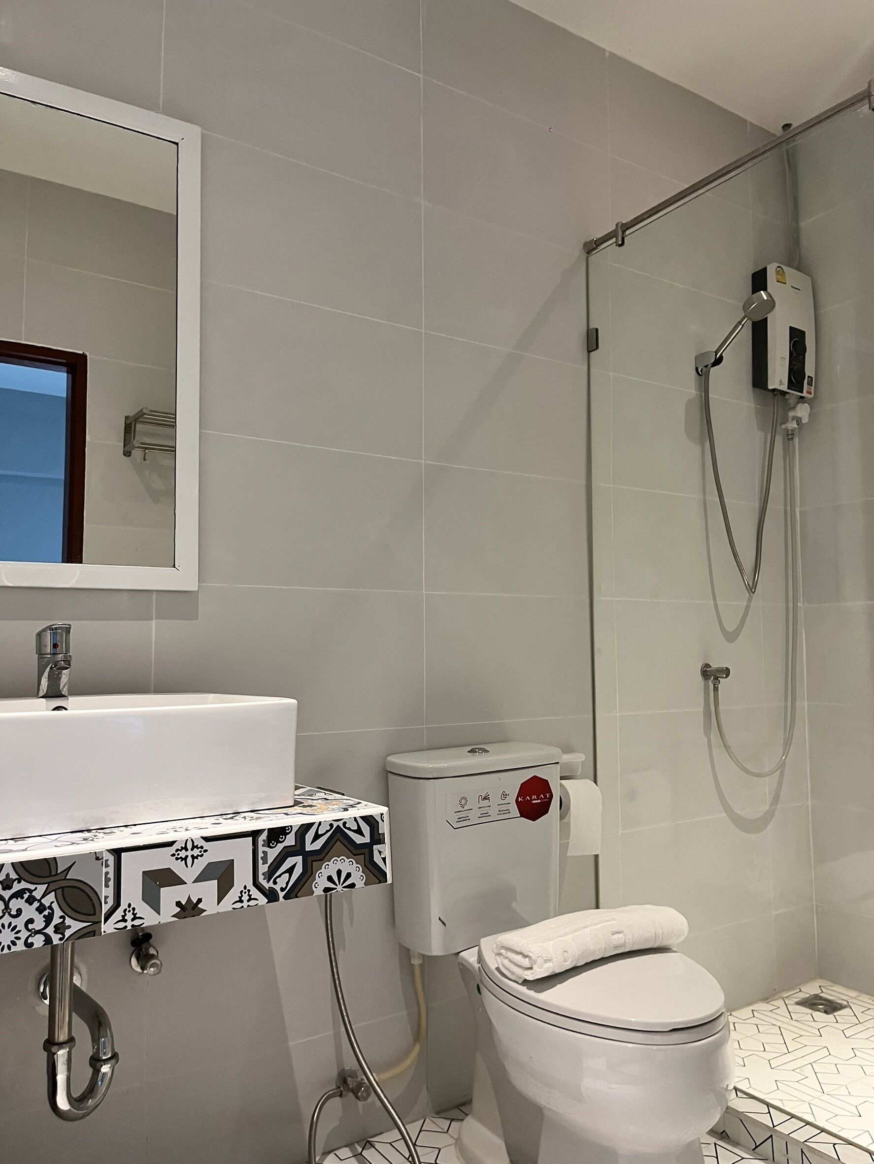 A bathroom with a white sink, toilet, and shower.