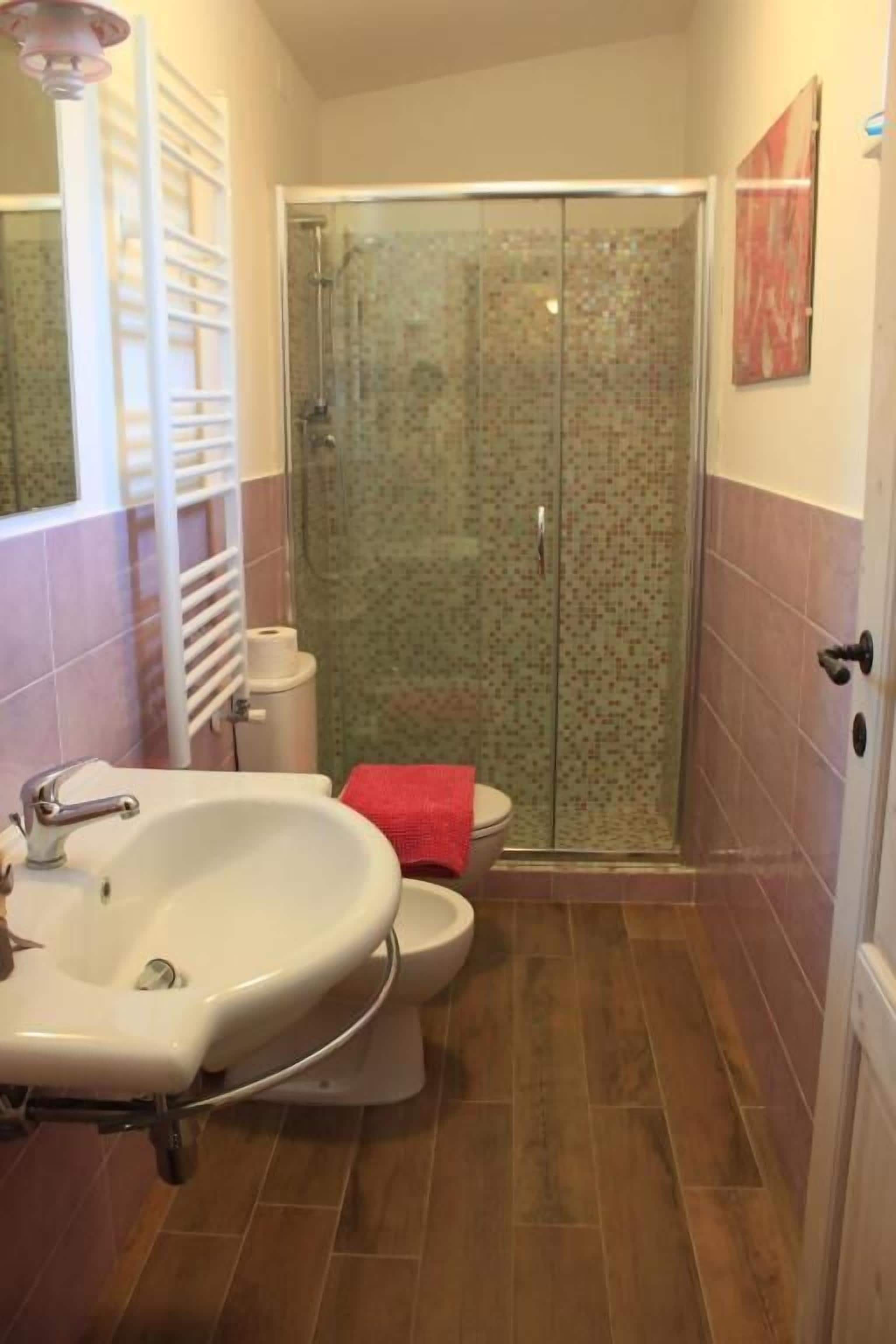 Un baño con ducha, inodoro y lavamanos.
