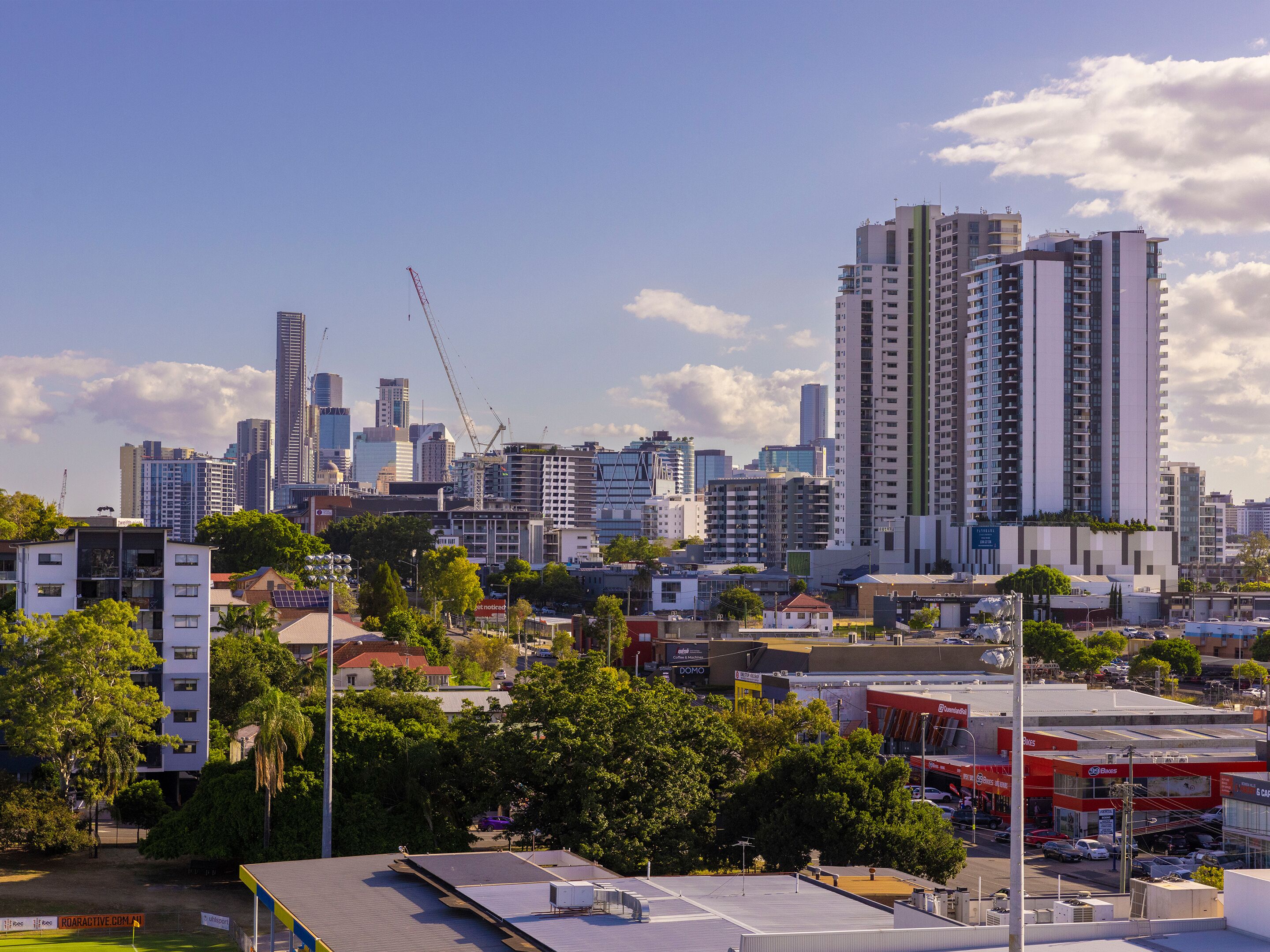 A city skyline with high-rise buildings, a construction crane, and a mix of commercial and residential structures.