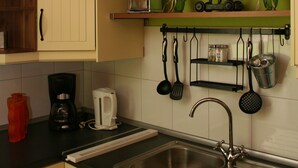 A kitchen with a sink, cabinets, and a hanging pot rack. - Eckhorst Farm, Tuscany (Güby)