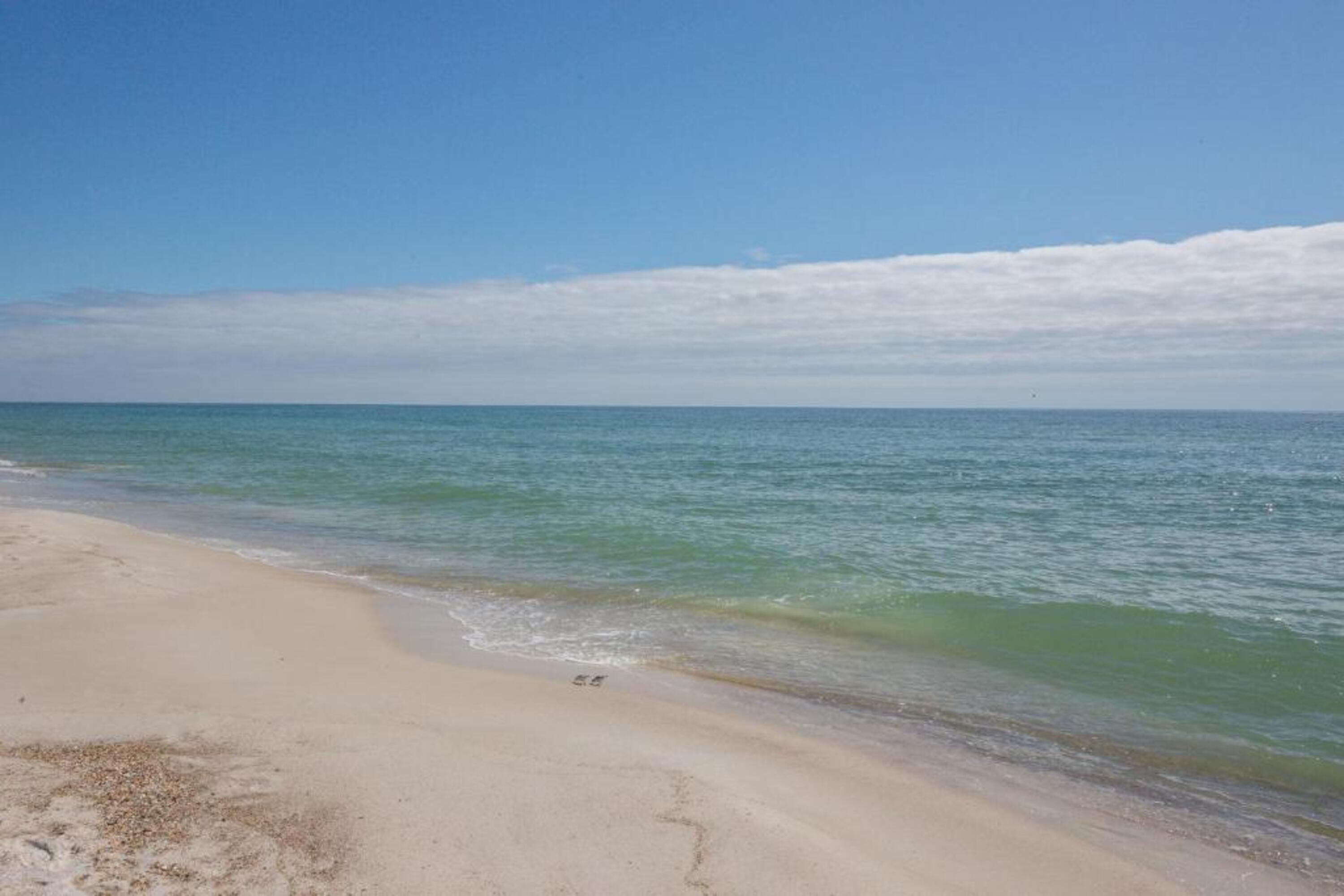 A beach with clear water and a sandy shore.