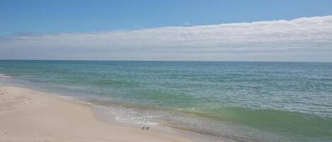 A beach with clear water and a sandy shore.