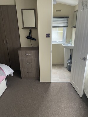 Un dormitorio con armario, mesita de noche y cama.