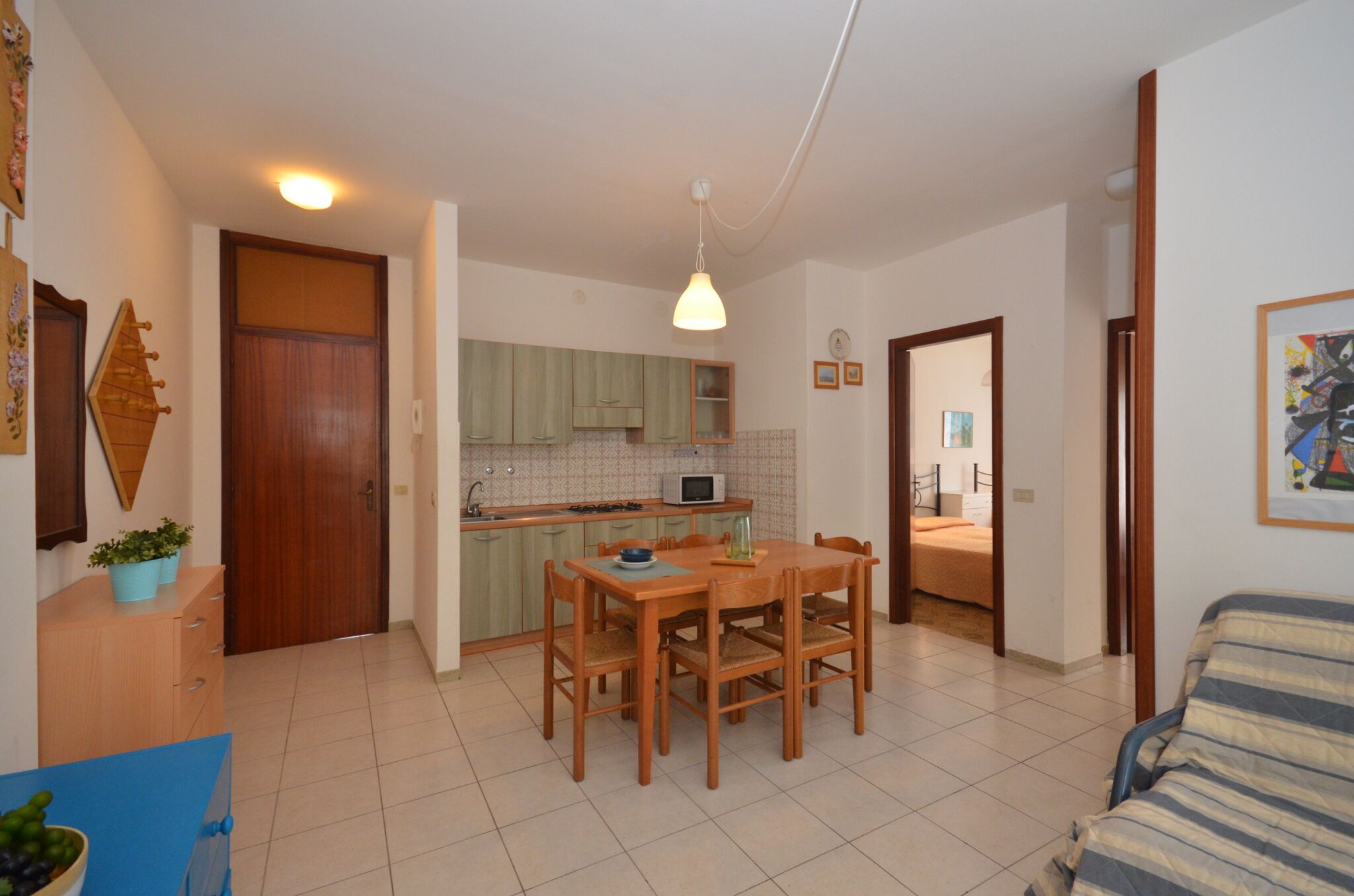 A compact living space with a kitchen, dining area, and a bedroom.
