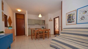 A compact living space with a kitchenette, a dining area, and a bed.