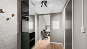 A modern interior with a wooden floor, a green shelving unit, and a white door. - Forenom Serviced Apartments Drammen (Drammen)