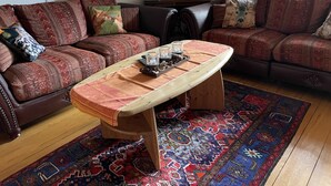 Ein gemütliches Wohnzimmer mit gemusterten Sofas, einem Holztisch und einem farbenfrohen Teppich.
