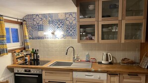 Eine Küche mit Holzausstattung, einem Geschirrspüler, einem Backofen und einem Spülbecken.