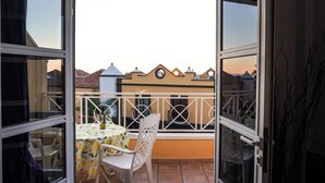 An open balcony with a table and chairs, a view of neighboring buildings, and a white railing. - Casa Juana, Adeje (Costa Adeje)