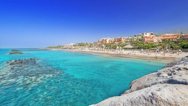 A coastal town with a beach, clear turquoise waters, and buildings along the shore. - Casa Juana, Adeje (Costa Adeje)