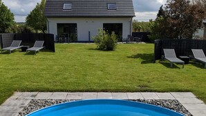 Ein Schwimmbad mit einem Haus im Hintergrund.