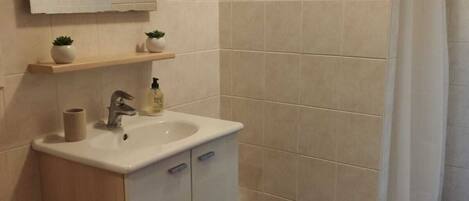 Ein Badezimmer mit Waschbecken, Spiegel und Dusche.