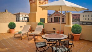 A rooftop terrace with a round table, chairs, and potted plants. - CAN FELIP Apartment with Fantastic Views (Palafrugell)