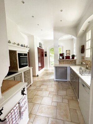 A spacious kitchen with a central island, built-in oven, and ample counter space.
