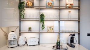 A modern kitchen with white appliances, a coffee maker, a toaster, and a wine glass on a tray. - First-Row Sea View Retreat · Old Town Antibes · 2BR with Balcony (Antibes)