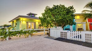 A house with a gravel driveway, a white picket fence, and a tree in the foreground. - 2 Bed 1.5 Boutique home w pool, with Seaview deck 100 yrds from Bachelor's Beach (Belnem)