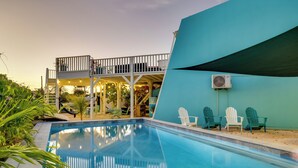 A swimming pool with a deck, outdoor seating, and a covered area with stairs. - 2 Bed 1.5 Boutique home w pool, with Seaview deck 100 yrds from Bachelor's Beach (Belnem)