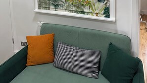 A room with a green sofa, a patterned wall, and a window with a view. - A Newly Refurbished Apartment in Notting Hill, London (London)