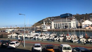 A marina with boats docked, a building labeled "LES PICHERIES DE FECAMP," and a clear blue sky. - Captain YOO - Bénéc - App Industriel sur le Port (Fécamp)