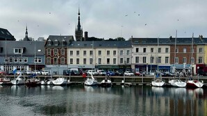 A marina with boats docked, a church spire, and various commercial buildings.