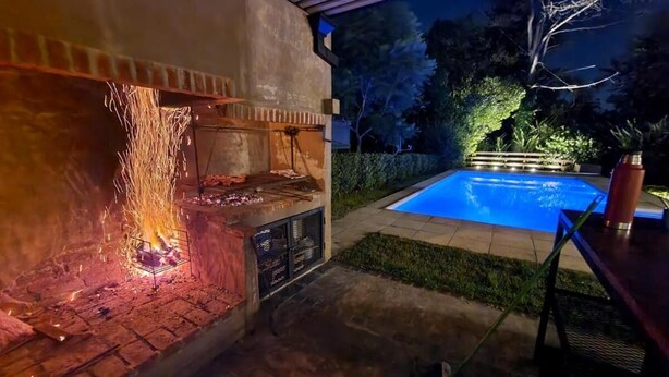 An outdoor barbecue area with a brick grill, a pool, and a covered seating area. - La Tribu, House with pool and whirlpool, ideal for families (Sierra de los Padres)