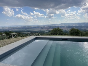 A rectangular swimming pool with a clear view of distant hills and a partly cloudy sky. - Panoramic villa (Città della Pieve)