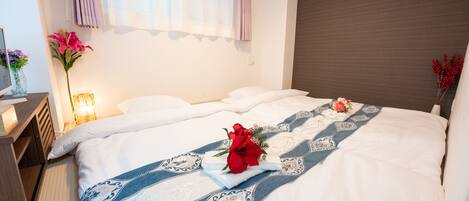 A hotel room with a large bed, a nightstand, a lamp, and a window with curtains.
