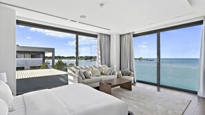 Ein modernes Hotelzimmer mit großem Balkon, einer Couch, einem Couchtisch und Meerblick.