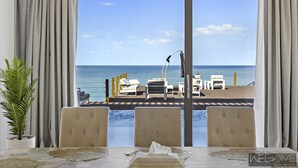 Ein Zimmer mit Meerblick, ein Esstisch mit Stühlen, eine Topfpflanze und ein Poolbereich mit Liegestühlen und einem Tisch.