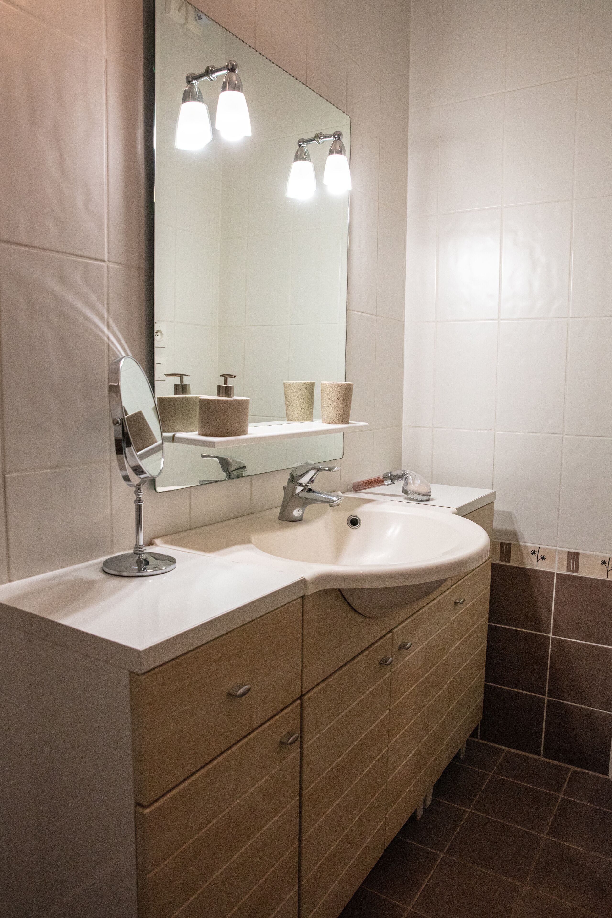 A bathroom with a sink, mirror, and towel rack.