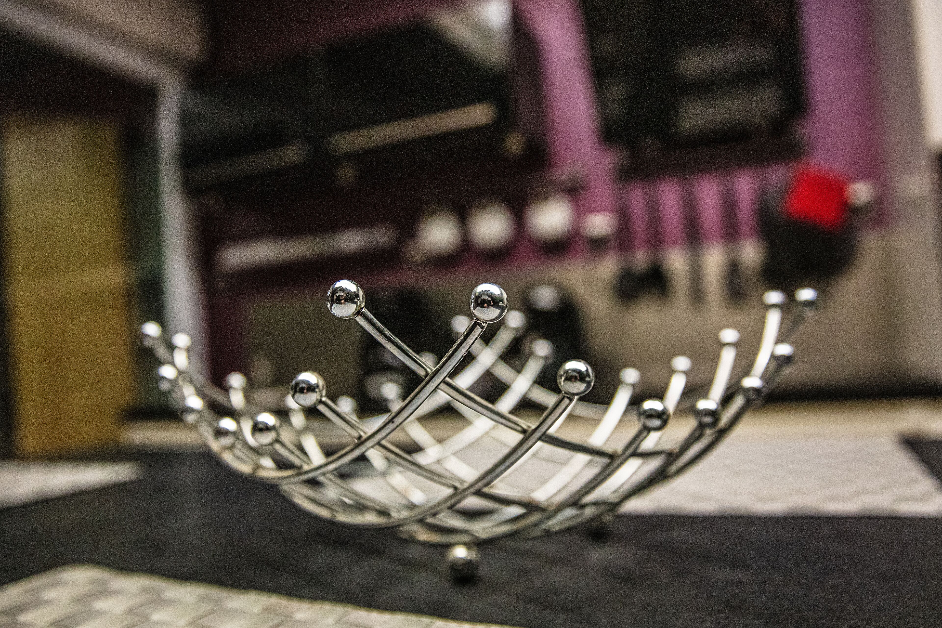 A metal crown-like object with spherical elements on a flat surface.