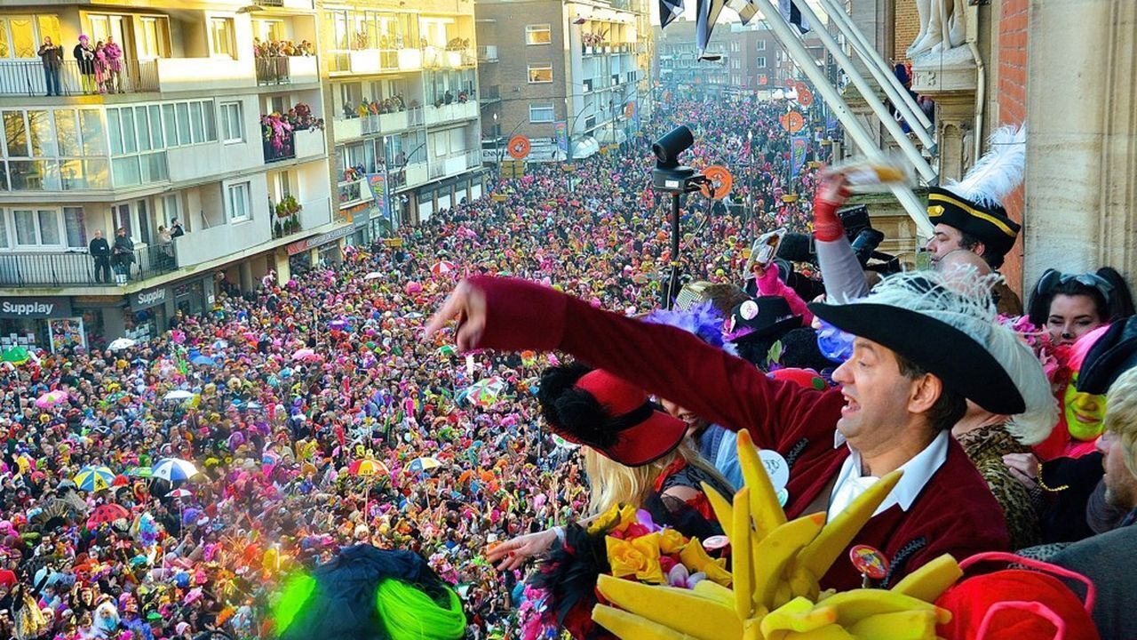 A crowded event with people in colorful costumes and a large gathering in an urban setting.