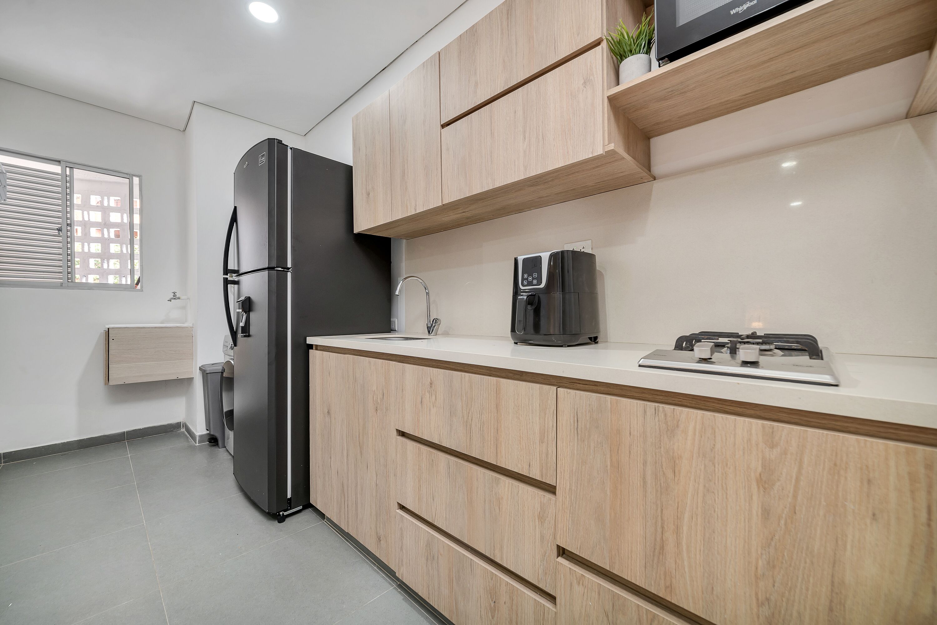 Eine moderne Küche mit einem Edelstahl-Kühlschrank, einer Kaffeemaschine und einem eingebauten Herd.