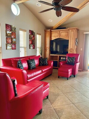 Relax in a stylish living area with a large sofa, armchairs, and a flat-screen TV.