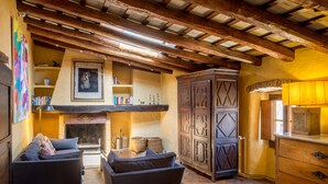 A cozy living room with a fireplace, wooden furniture, and a bookshelf. - CAN FELIP Penthouse with Fantastic Views (Palafrugell)