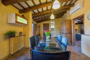 A dining area with a glass table, black chairs, a vase of flowers, and a wooden ceiling. - CAN FELIP Penthouse with Fantastic Views (Palafrugell)