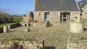 A stone building with a tiled roof, a small window, and a stone well. - Kerdu Pointe de la Torche - 200 m from the beach (Plomeur)