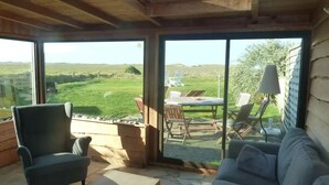 A room with a large sliding glass door leading to an outdoor patio with a table and chairs. - Kerdu Pointe de la Torche - 200 m from the beach (Plomeur)