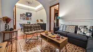 En stue med sofa, lænestole, sofabord og et spiseområde med bord og stole.