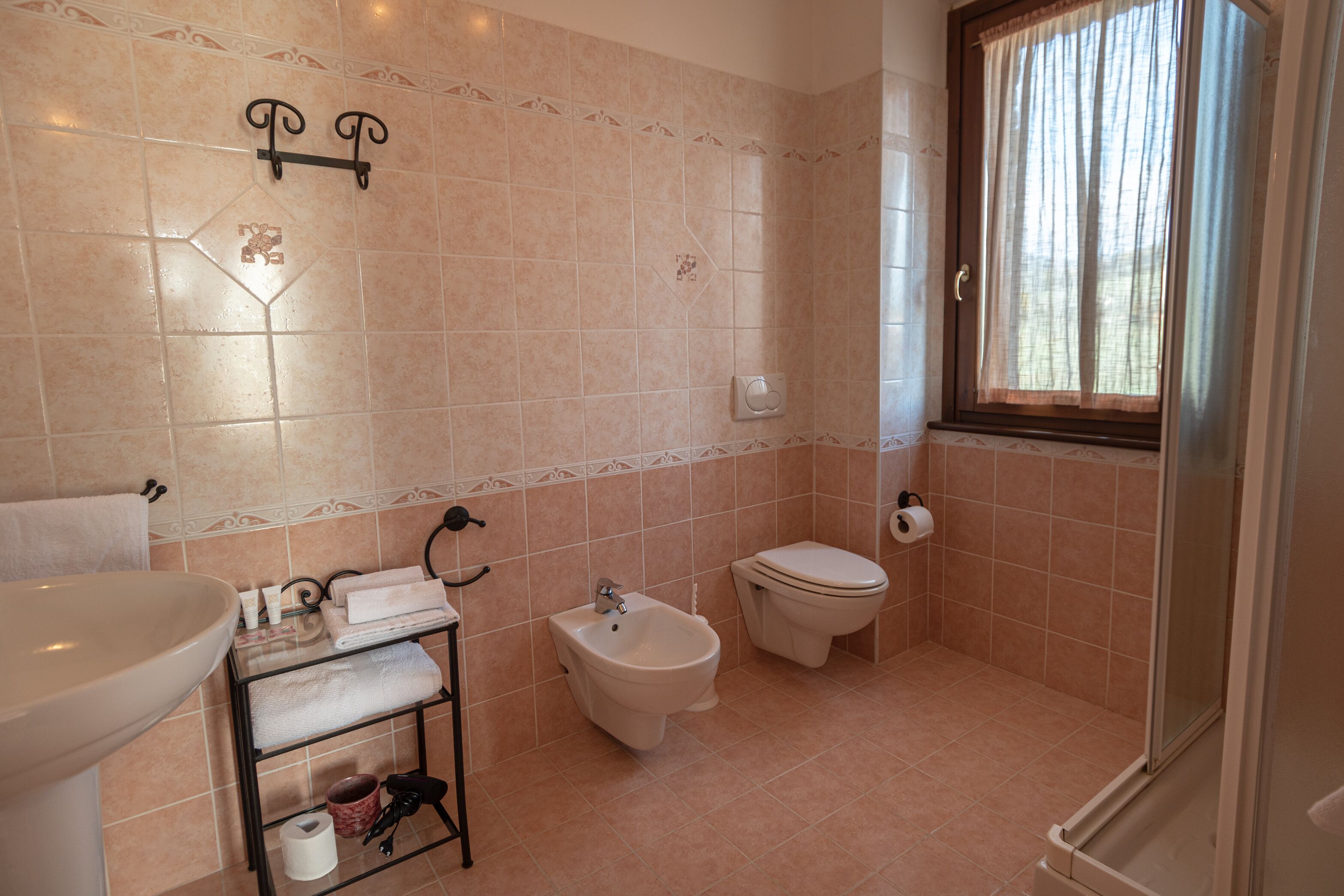 Et badeværelse med toilet, bidet og vask.