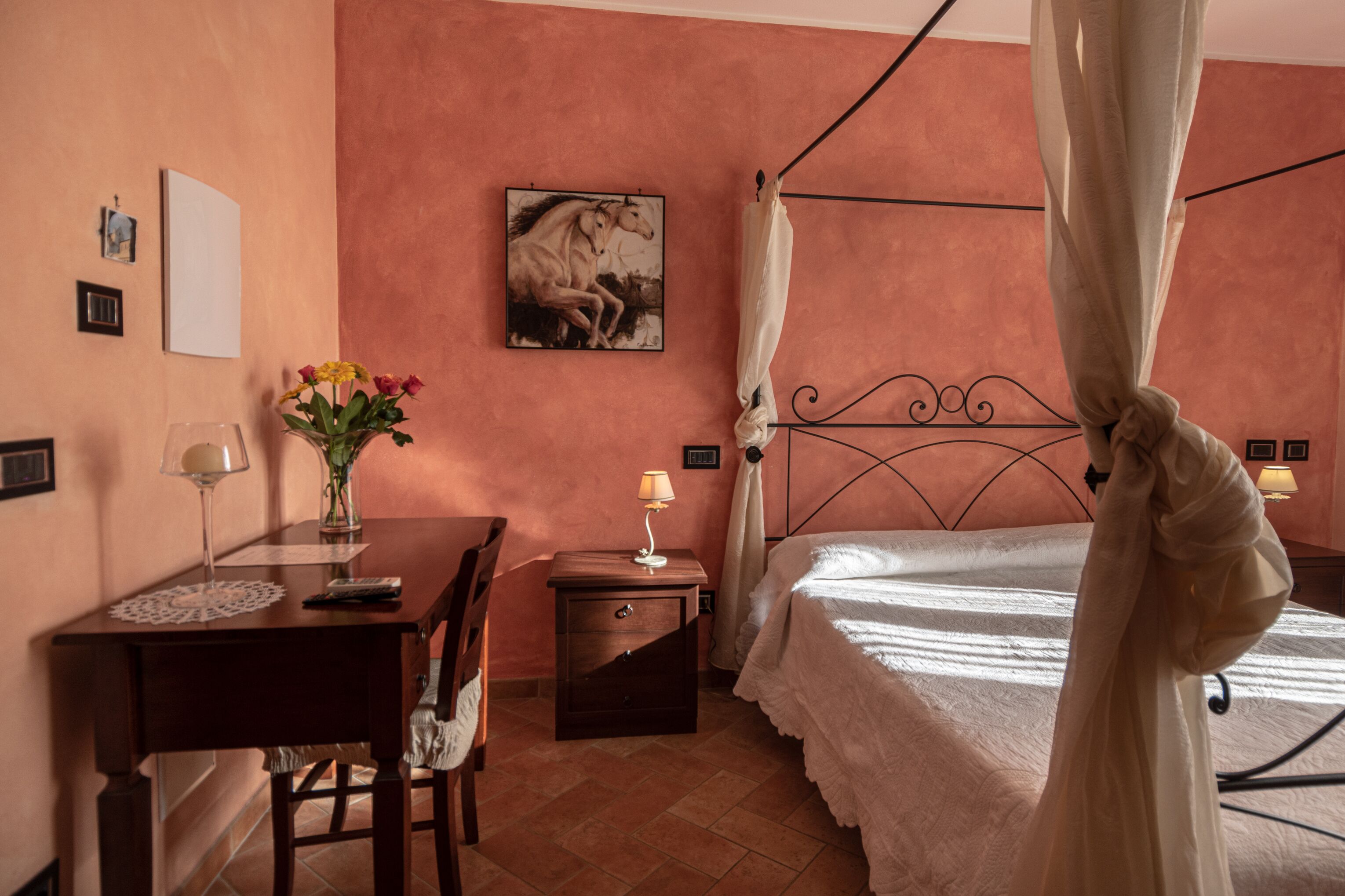 Ein Schlafzimmer mit Bett, Nachttisch, Schreibtisch, Stuhl, Lampe und einem Bild an der Wand.