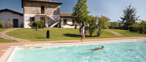 Una piscina al aire libre de temporada, sombrillas