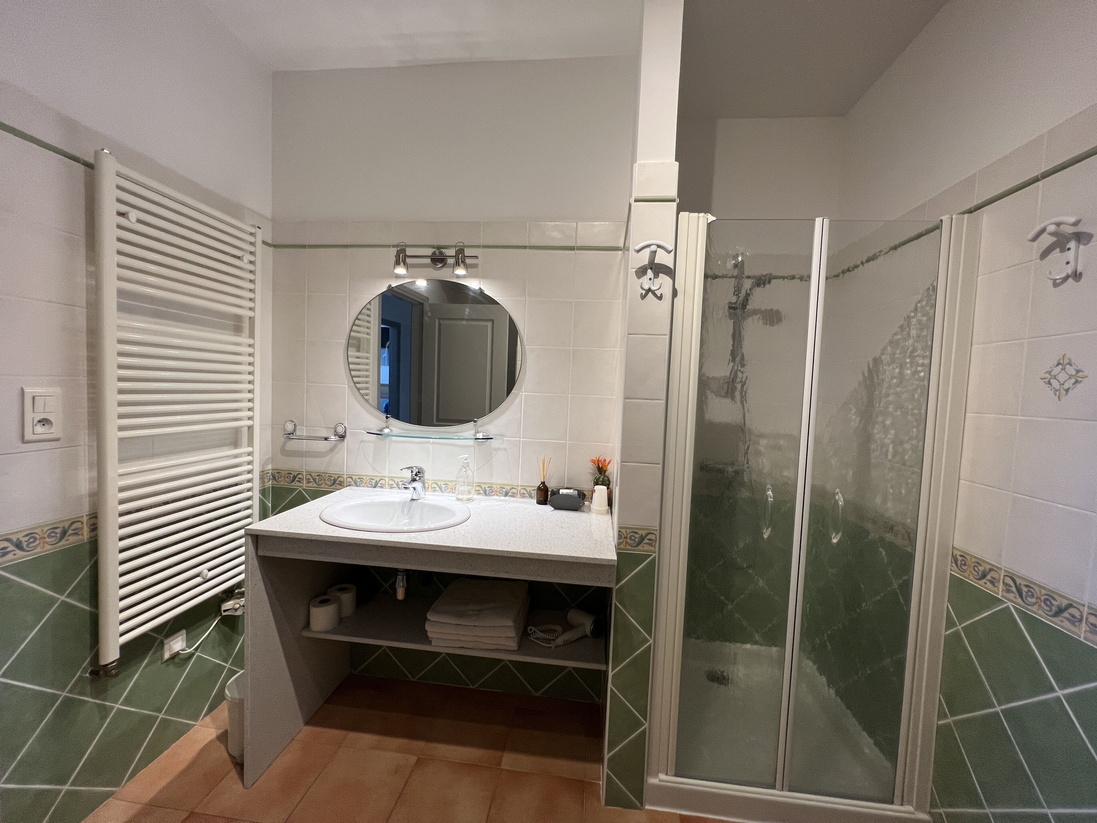 Un baño con ducha, lavamanos y espejo.