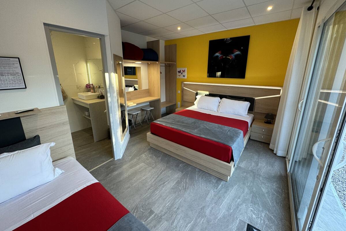 Een moderne hotelkamer met een groot bed, een bureau en een badkamer.