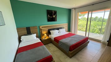 Una habitación de hotel con dos camas, un balcón con vistas y un cuadro en la pared.