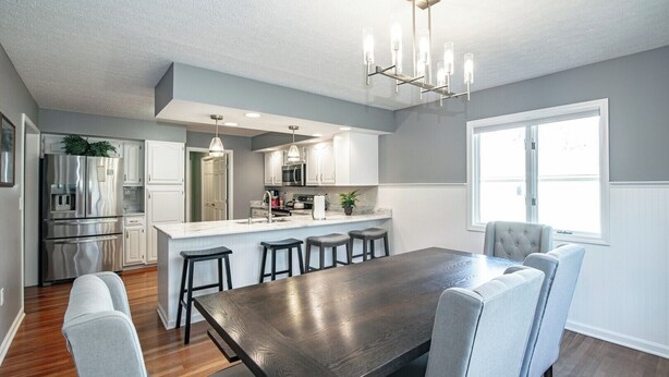 A modern kitchen with a central island, stainless steel appliances, and a chandelier. - Country  Clean  Cozy (Elizabethtown)