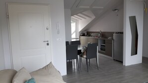 A modern apartment with a dining area, kitchen, and a living room with a sofa and cushions. - Penthouse penthouse by the sea Rovinj, Residenza Federica (Rovigno)