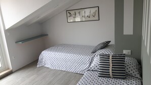 A small, cozy bedroom with a sloped ceiling, a single bed with patterned bedding, a striped pillow, and a framed artwork on the wall. - Penthouse penthouse by the sea Rovinj, Residenza Federica (Rovigno)